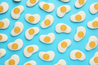 Photo of Tasty jelly candies in shape of egg on light blue background, flat lay