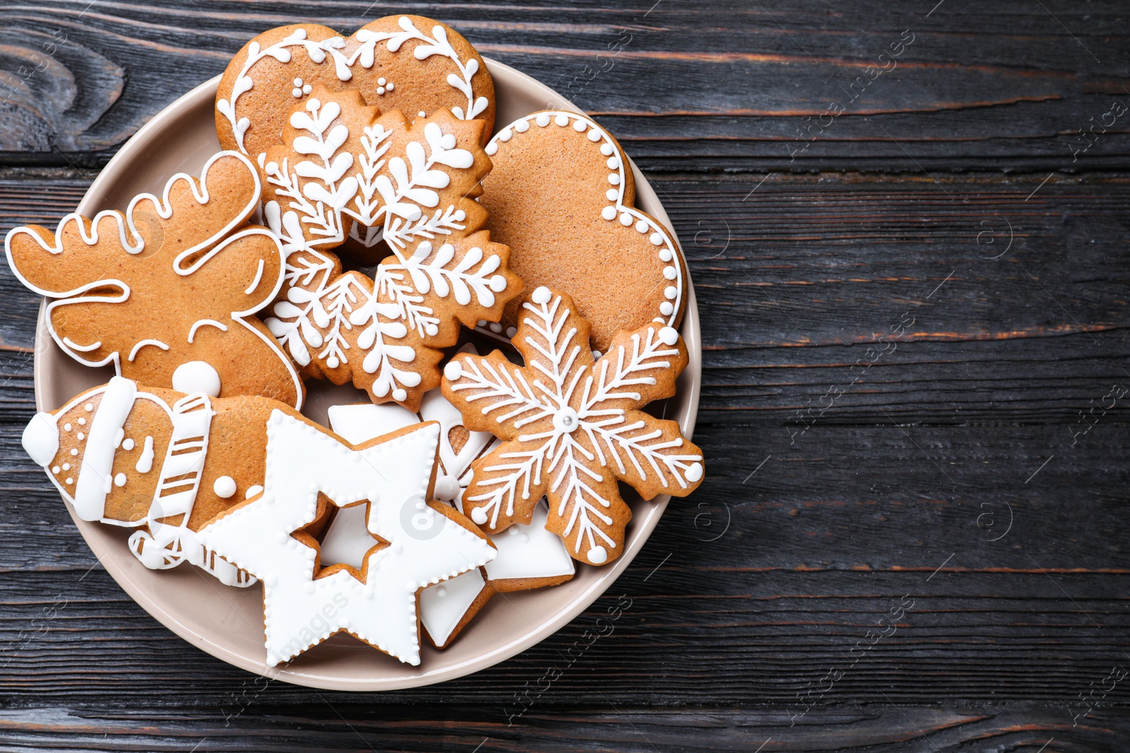 Photo of Delicious Christmas cookies on black wooden table table, top view