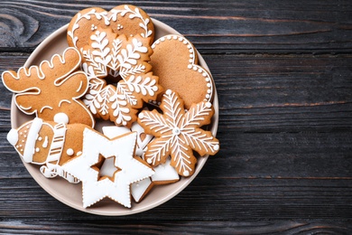 Delicious Christmas cookies on black wooden table table, top view