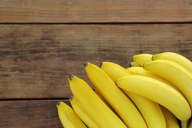 Ripe yellow bananas on wooden table, flat lay. Space for text