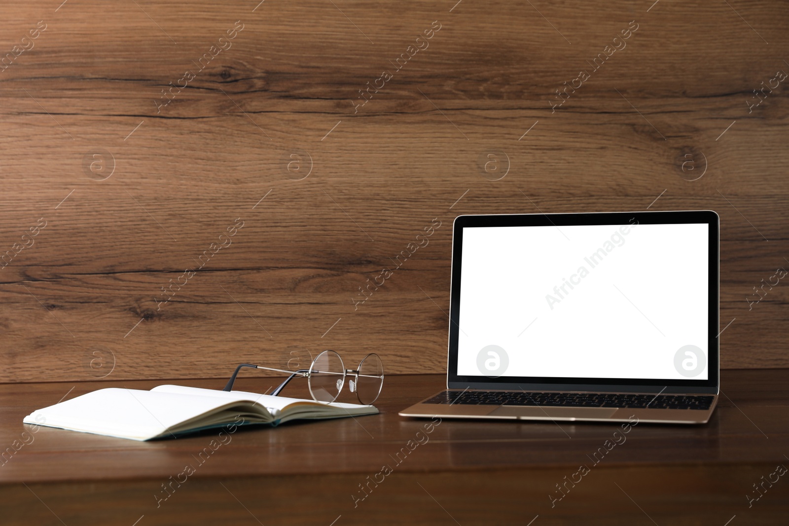 Photo of Workplace with modern laptop on wooden table. Mockup for design