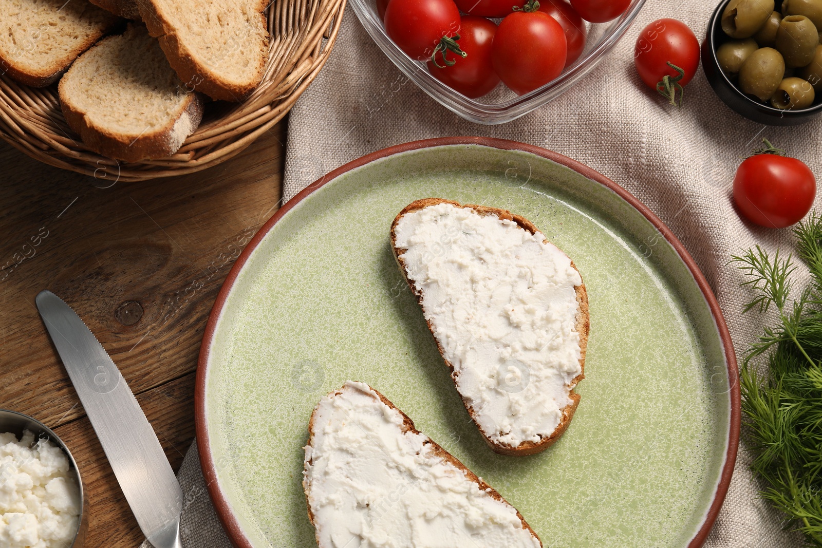 Photo of Delicious ricotta bruschettas and products on wooden table, flat lay