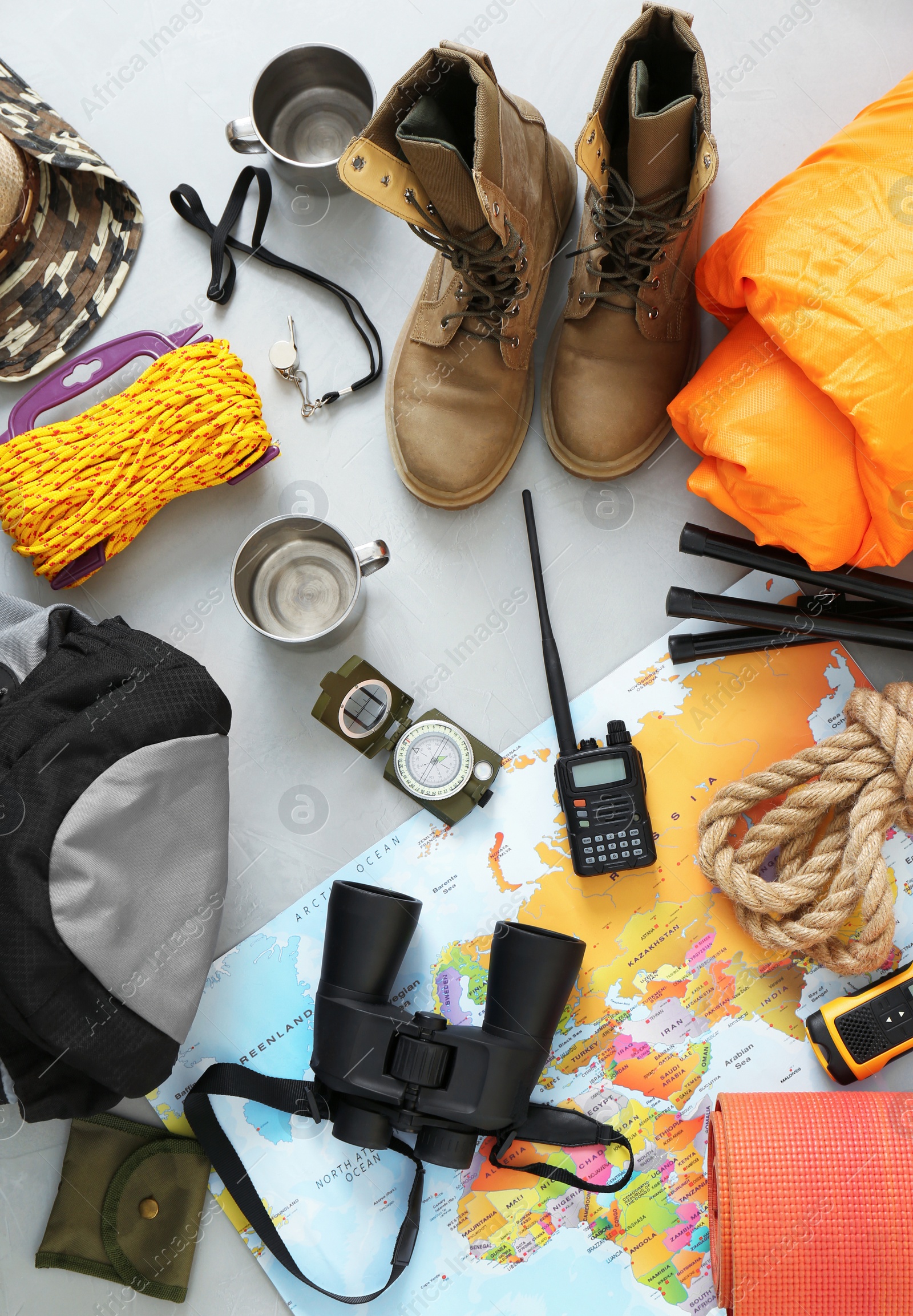 Photo of Flat lay composition with sleeping bag and camping equipment on grey background