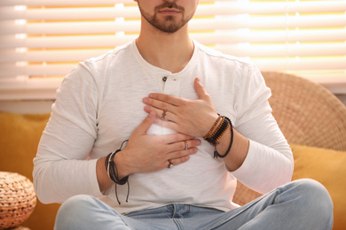 Photo of Young man during self-healing session in therapy room, closeup