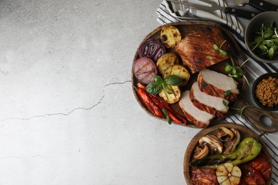 Delicious grilled meat and vegetables served on light grey table, flat lay. Space for text