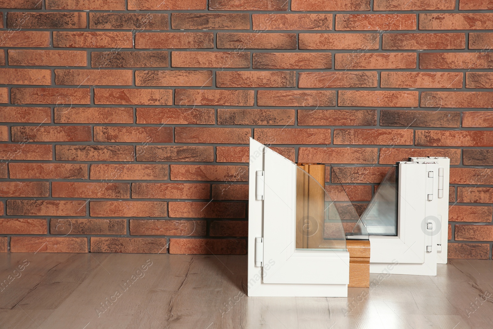 Photo of Samples of modern window profiles on floor against brick wall, space for text. Installation service