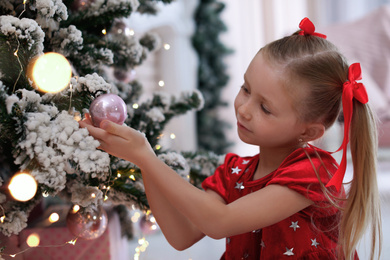 Photo of Cute little child near Christmas tree at home