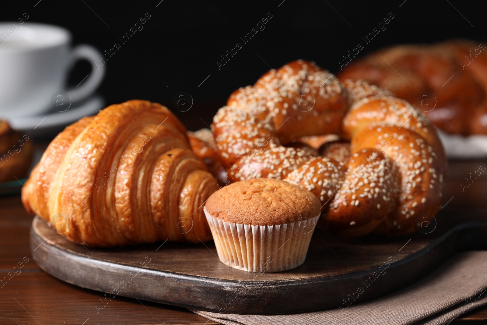 Photo of Different tasty freshly baked pastries on wooden table, closeup