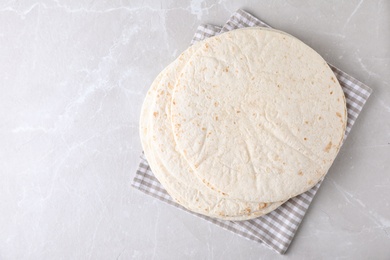 Photo of Corn tortillas on light background, top view with space for text. Unleavened bread