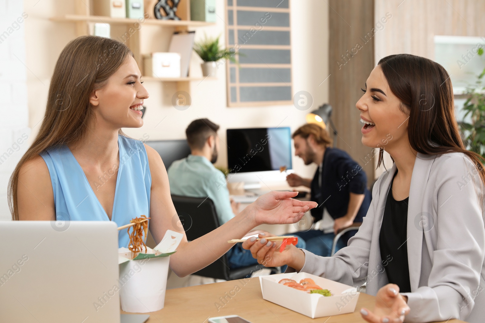 Photo of Office employees having lunch at workplace. Food delivery