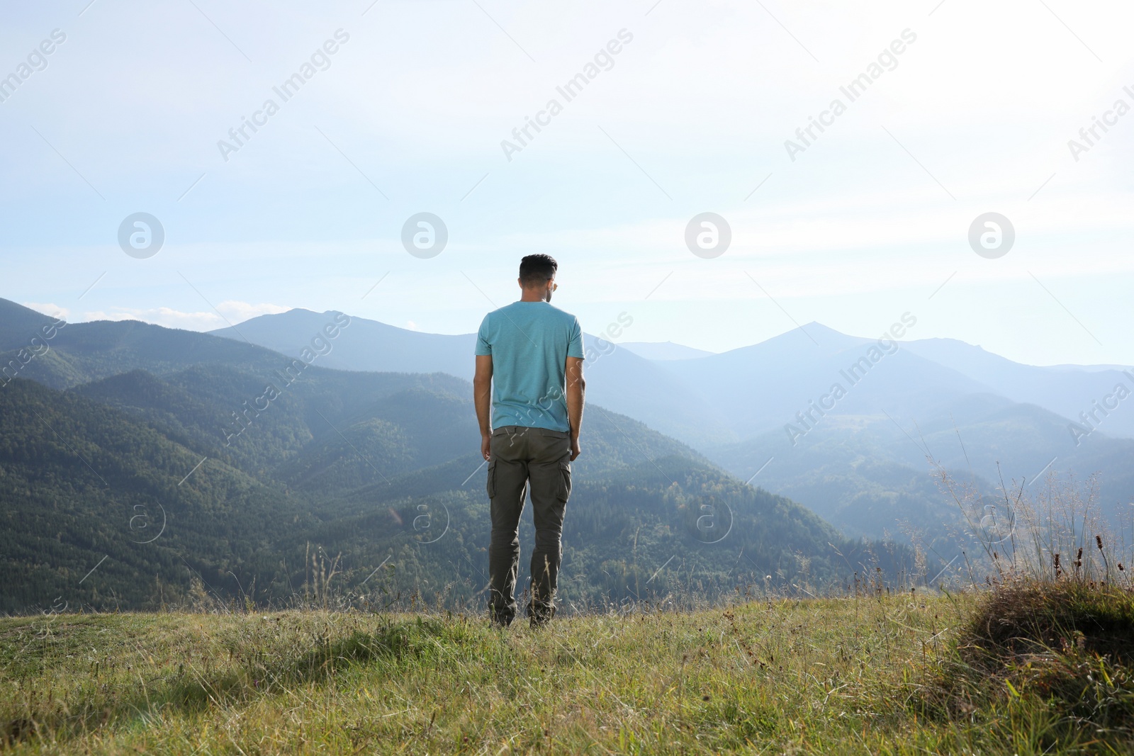 Photo of Man enjoying beautiful mountain landscape, back view
