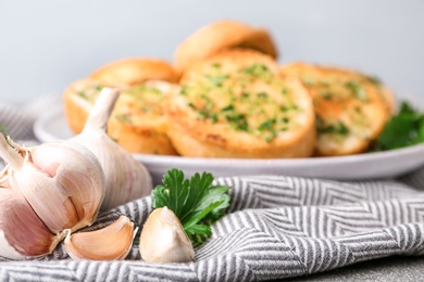 Photo of Slices of toasted bread with garlic and herbs on table