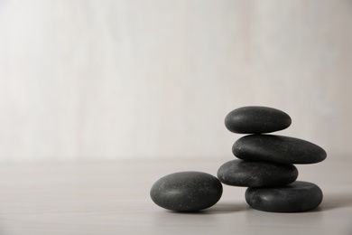 Photo of Black spa stones on light background. Space for text