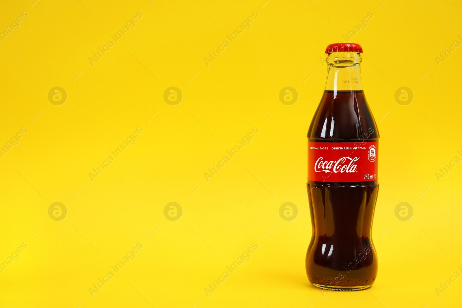 Photo of MYKOLAIV, UKRAINE - NOVEMBER 14, 2018: Bottle of Coca-Cola on color background. Space for text