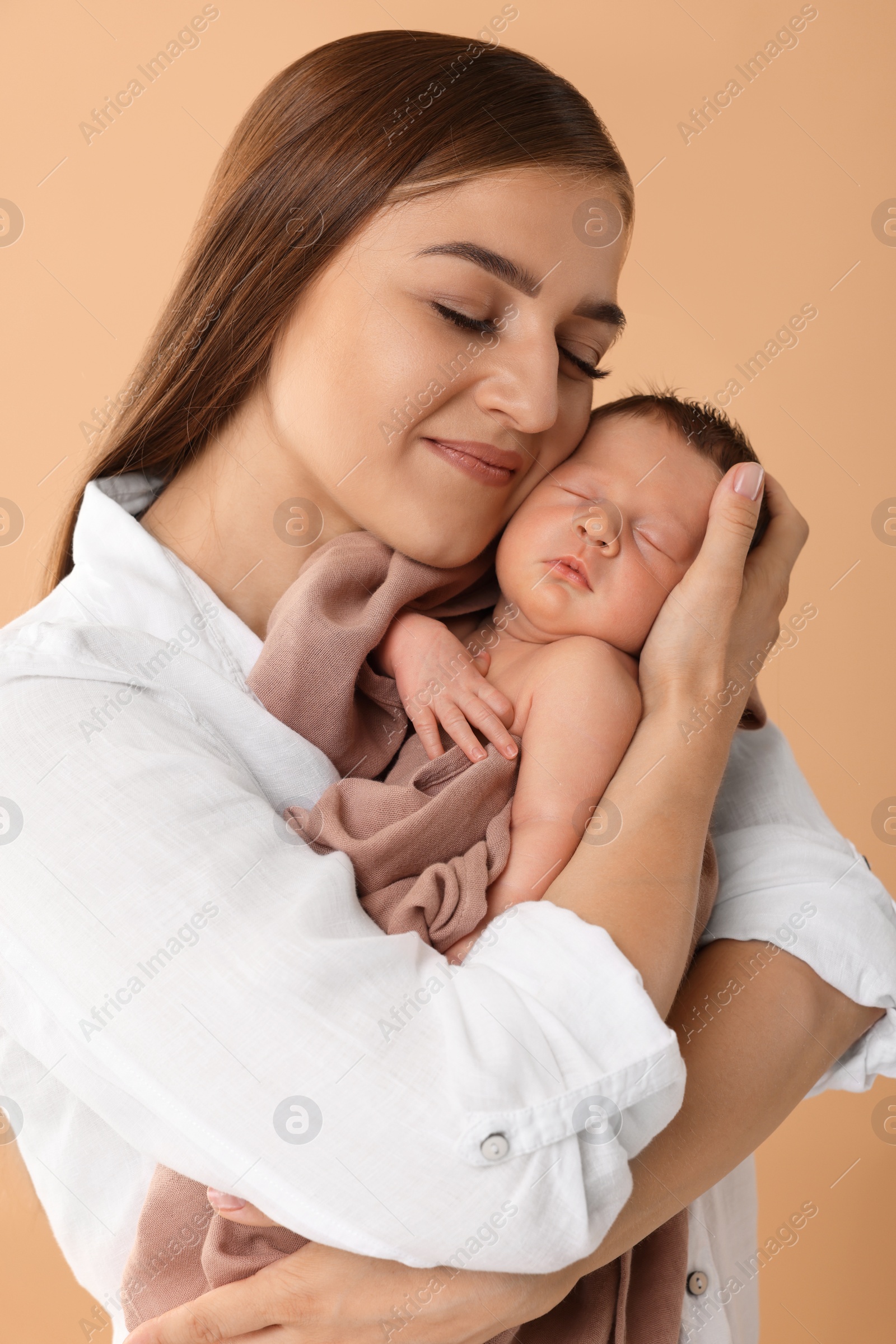 Photo of Mother with her cute newborn baby on beige background