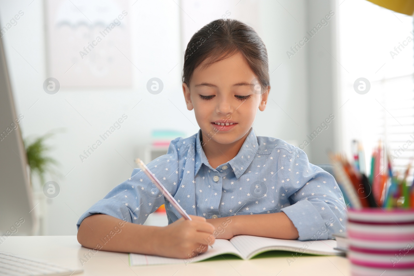 Photo of Distance learning, studying at home. Girl having online school lesson during quarantine and lockdown due to Covid-19 pandemic