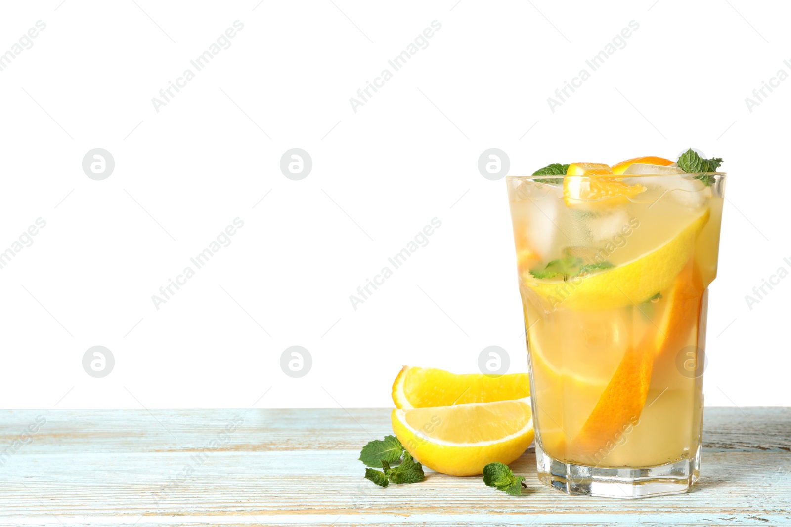 Photo of Glass of citrus refreshing drink on wooden table against white background