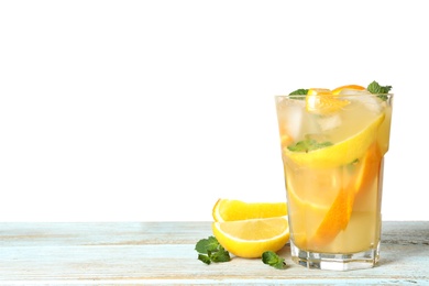 Photo of Glass of citrus refreshing drink on wooden table against white background