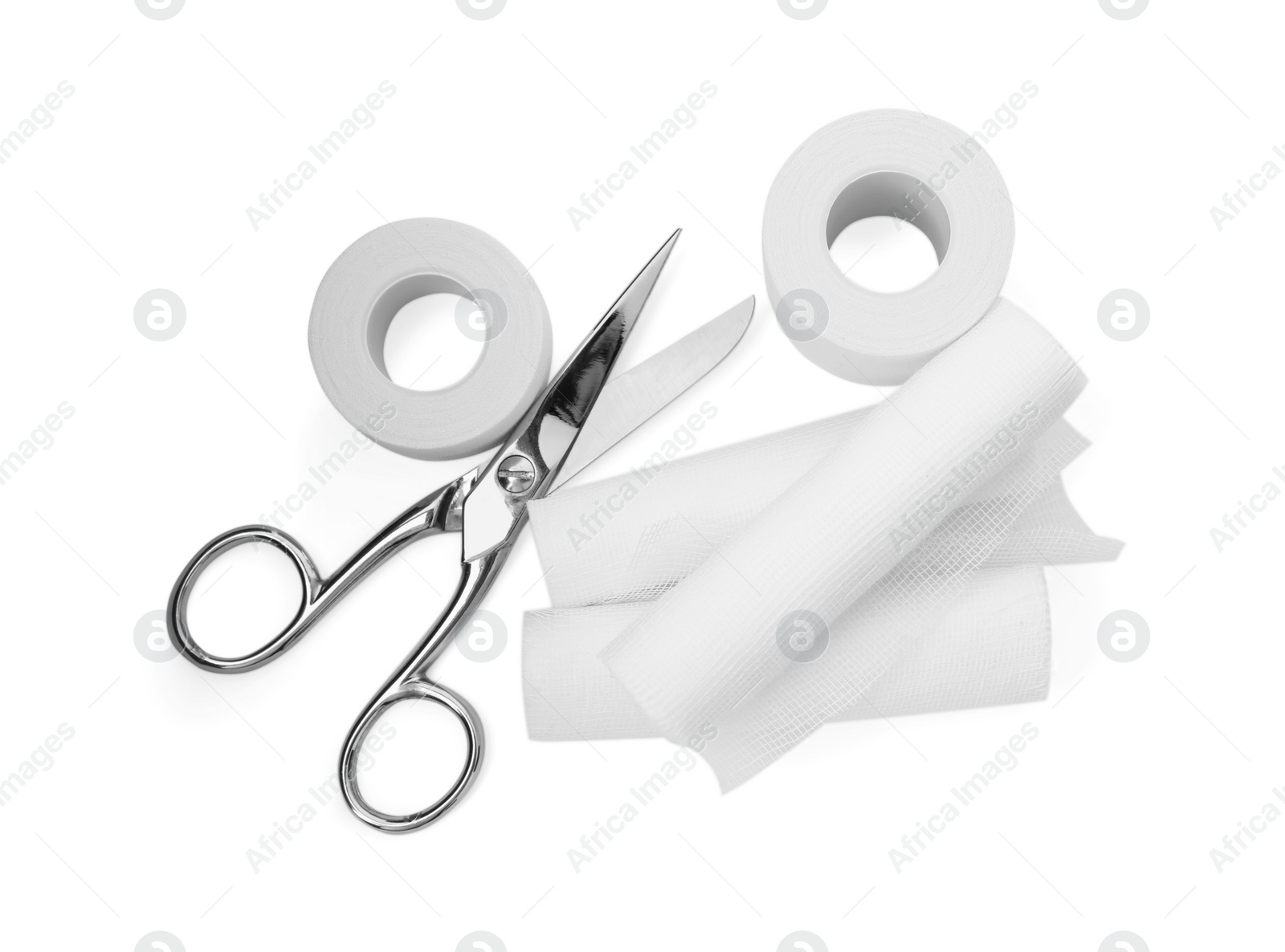 Photo of Medical bandage rolls, sticking plaster and scissors on white background, top view