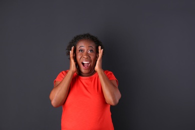 Portrait of happy African-American woman on black background