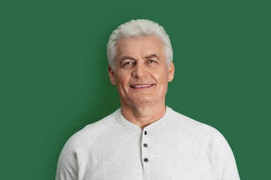 Portrait of handsome mature man on color background