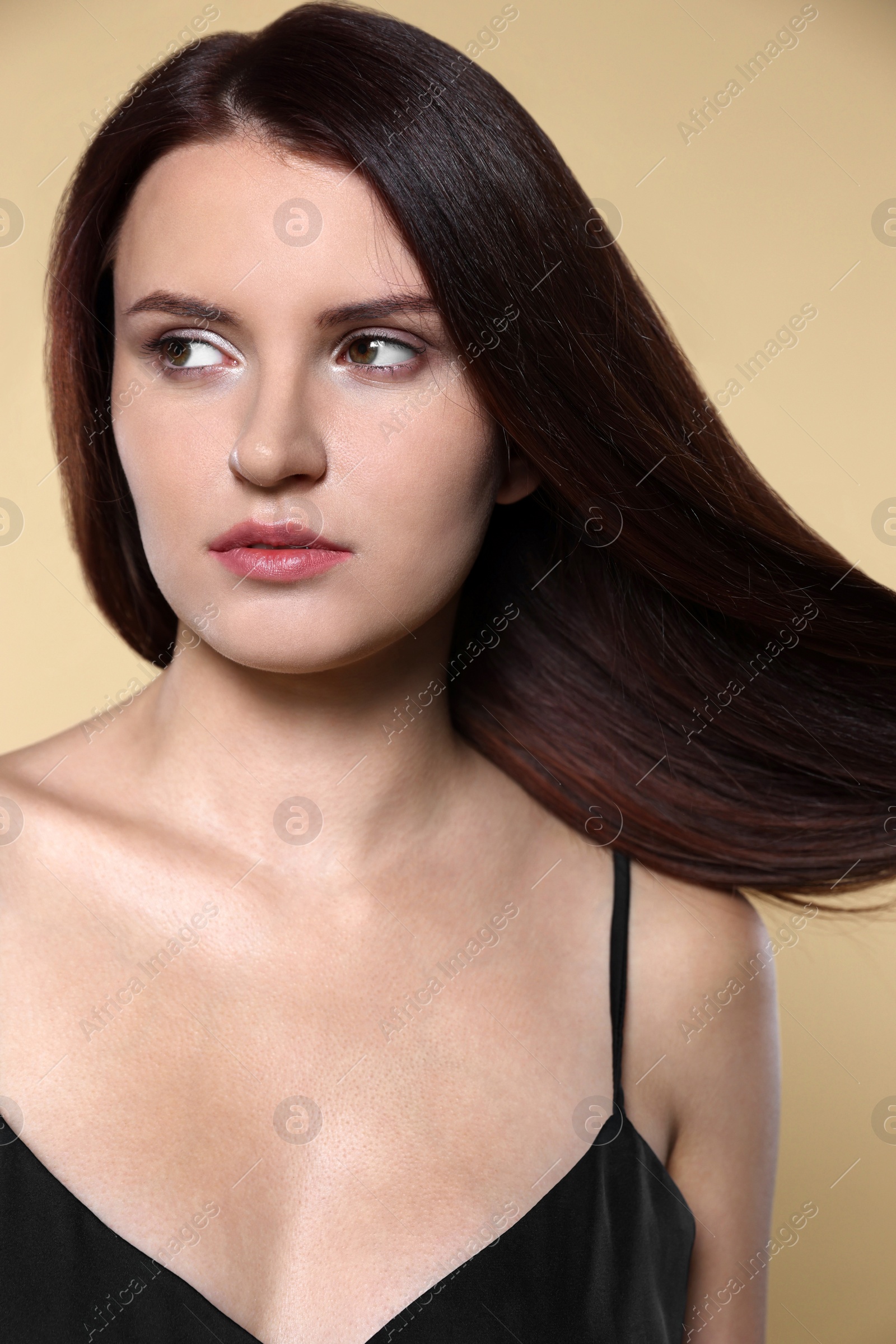 Photo of Portrait of beautiful young woman with healthy strong hair on beige background