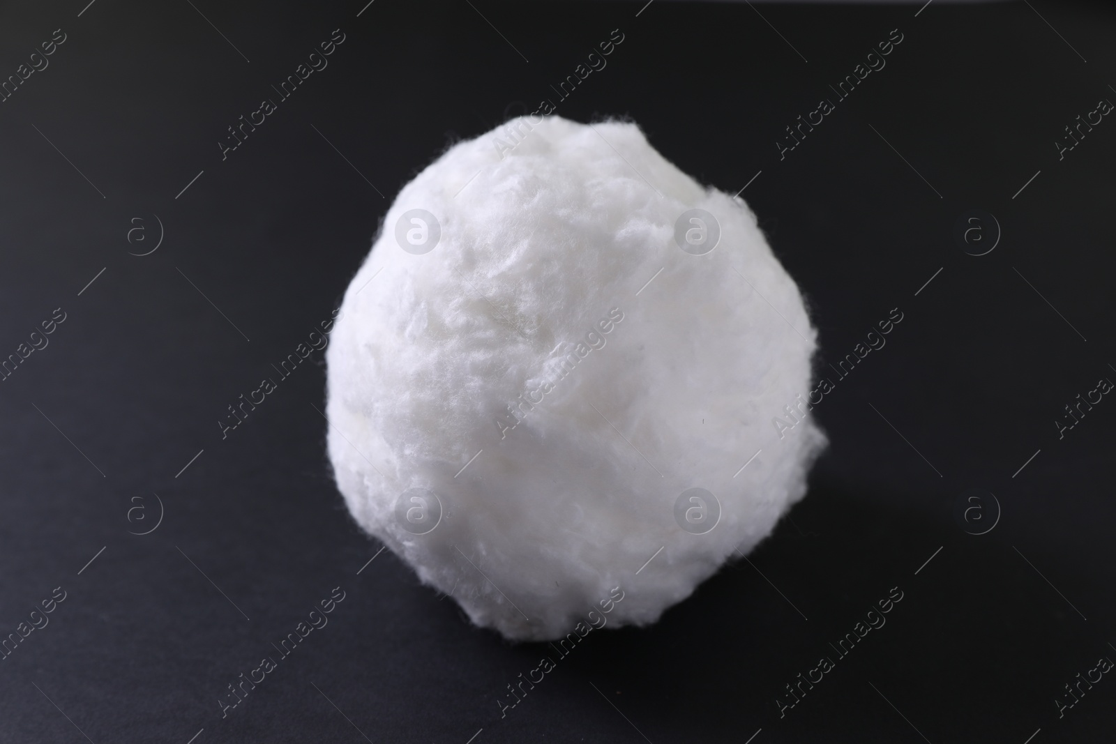 Photo of Ball of clean cotton wool on dark background, closeup