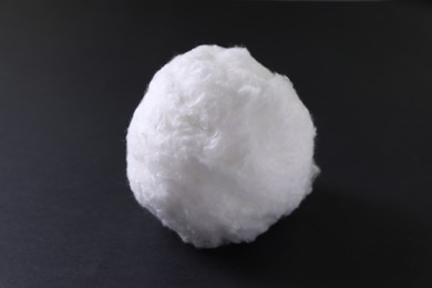 Photo of Ball of clean cotton wool on dark background, closeup