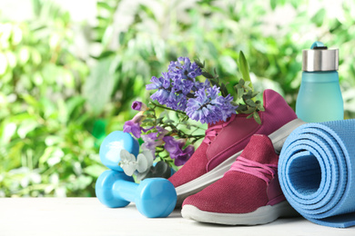 Photo of Composition with spring flowers and sports items on blurred green background