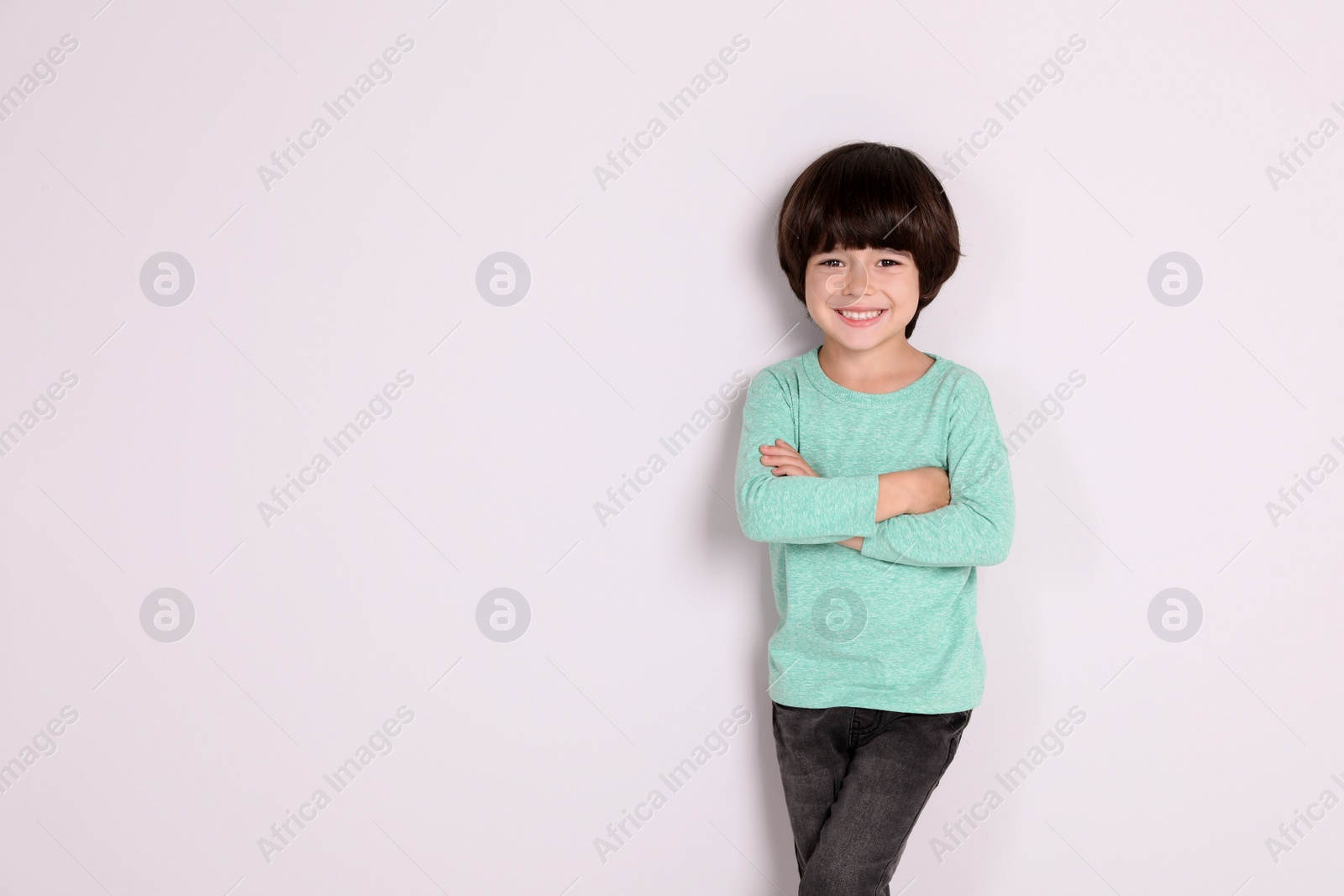 Photo of Portrait of cute little boy on white background, space for text