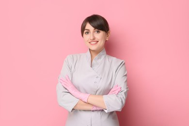 Cosmetologist in medical uniform on pink background