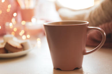 Cup of delicious hot winter drink on white table