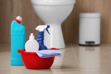 Photo of Different toilet cleaning supplies on floor indoors, space for text
