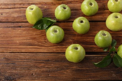 Fresh ripe green apples with water drops on wooden table. Space for text