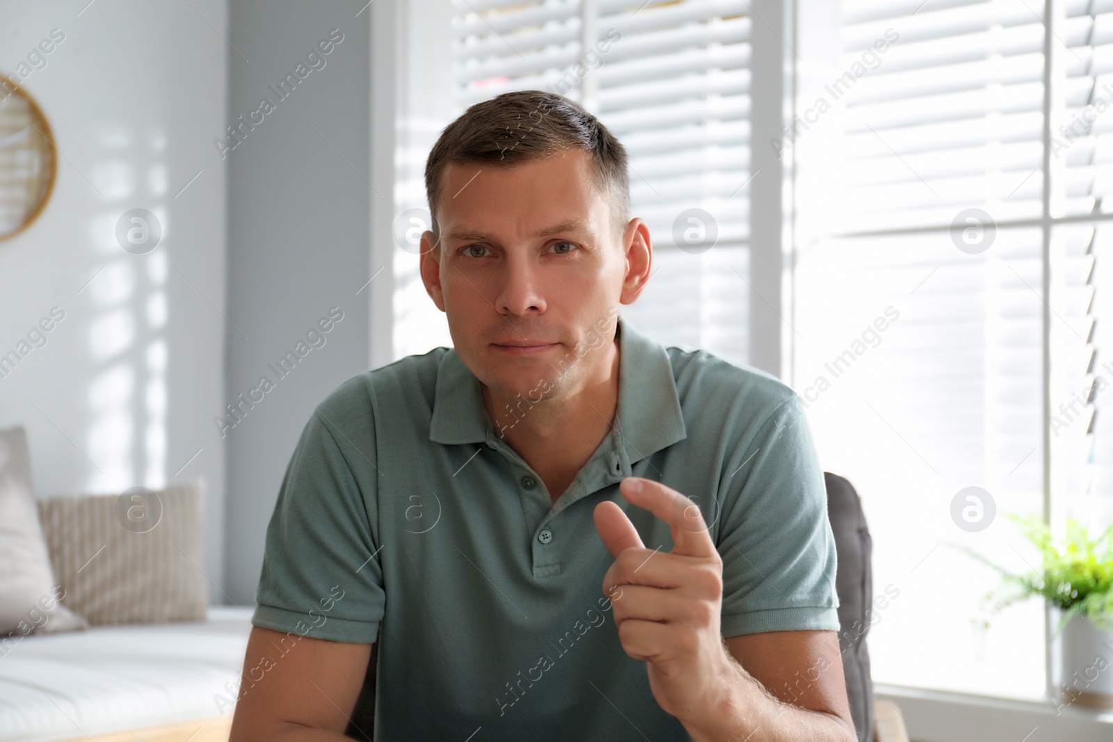 Photo of Man talking to his coworkers through video conference indoors, view from webcam