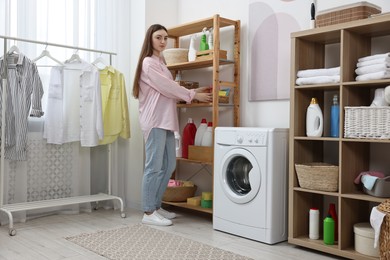 Photo of Beautiful young woman with basket of napkins in laundry room