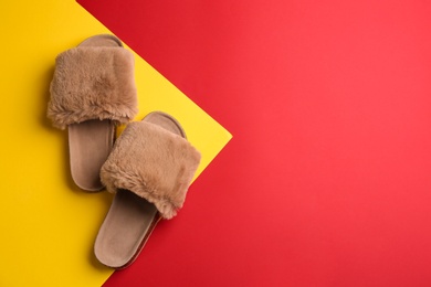 Photo of Pair of soft slippers on color background, flat lay. Space for text