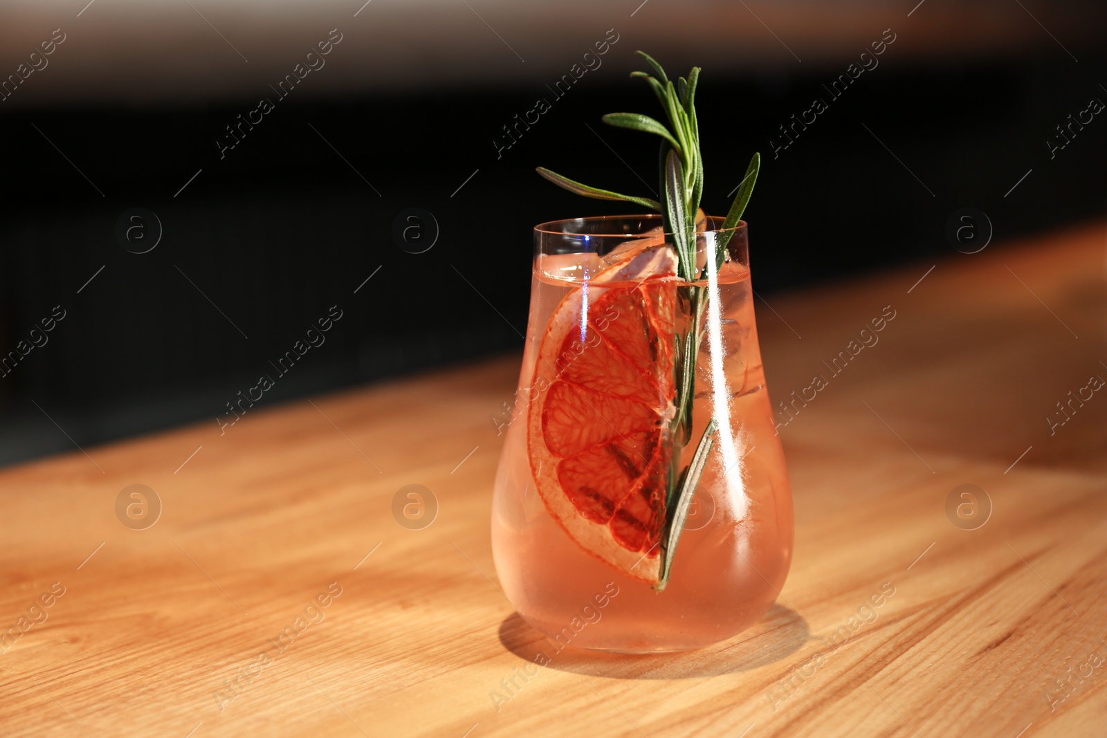 Photo of Glass of delicious cocktail with vodka on wooden counter in bar