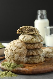 Tasty matcha cookies and powder on grey table