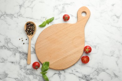 Photo of Cutting board, basil, spices and tomatoes on white marble table, flat lay. Space for text