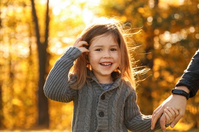 Photo of Cute little girl with mother in sunny park. Autumn walk