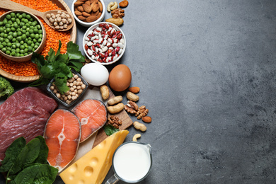 Photo of Products rich in protein on grey table, flat lay. Space for text