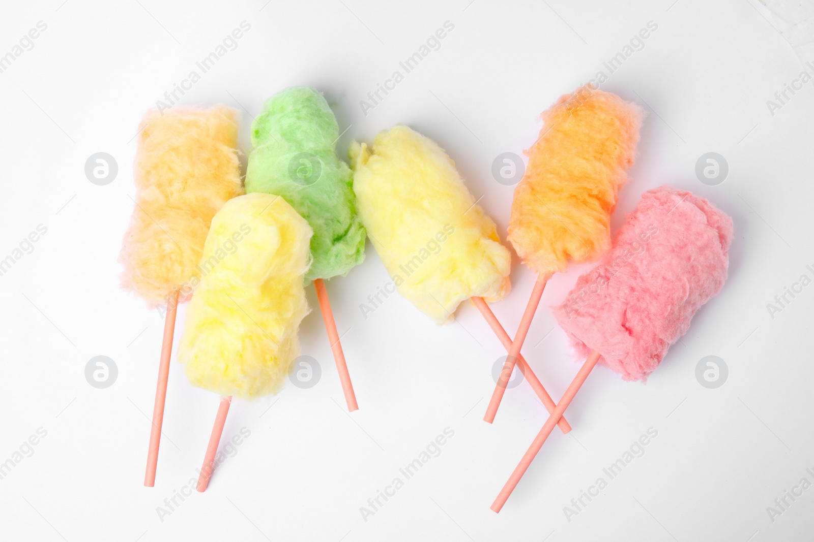 Photo of Straws with yummy cotton candy on white background, top view