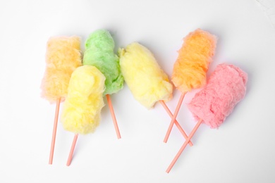 Straws with yummy cotton candy on white background, top view