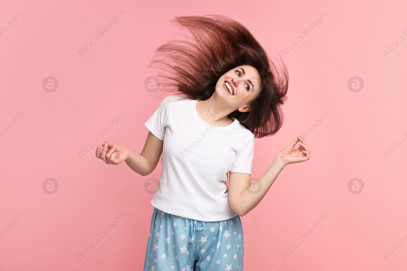 Photo of Happy woman in pyjama shaking head on pink background