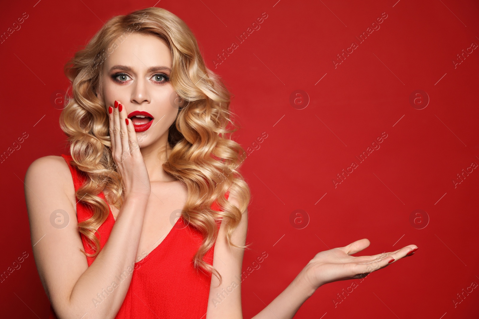 Photo of Portrait of surprised woman on red background, space for text