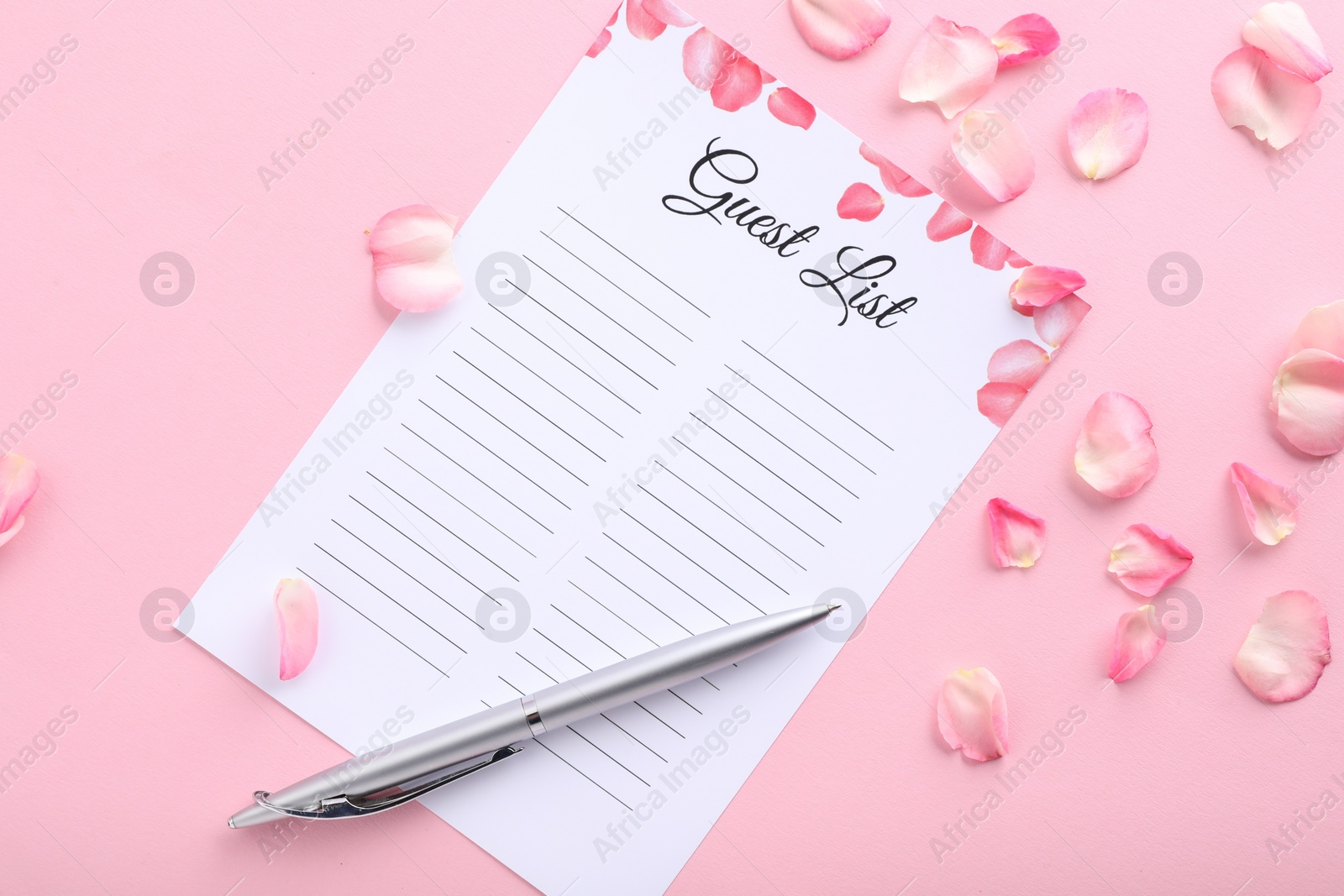 Photo of Guest list, pen and petals on pink background, flat lay. Space for text