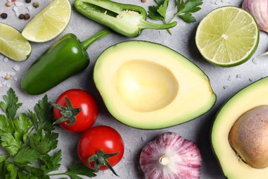 Fresh ingredients for guacamole on light grey table, flat lay