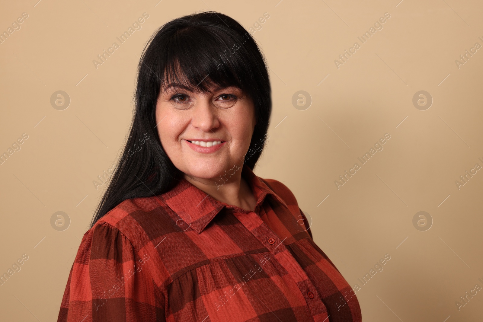 Photo of Beautiful overweight mature woman with charming smile on beige background