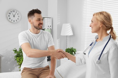 Doctor shaking hands with patient in clinic